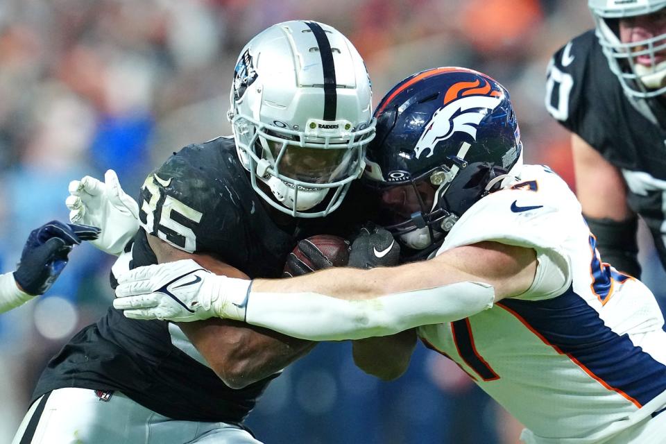 Jan 7, 2024; Paradise, Nevada, USA; Las Vegas Raiders running back Zamir White (35) is tackled by Denver Broncos linebacker Josey Jewell (47) during the third quarter at Allegiant Stadium. Mandatory Credit: Stephen R. Sylvanie-USA TODAY Sports