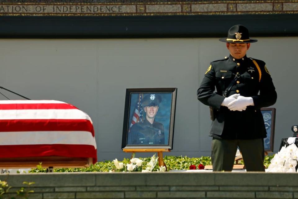 Family, friends, city officials and fellow officers salute fallen Los Angeles Police Officer Houston Tipping as they gather at Forest Lawn Hollywood Hills - Hall of Liberty Mosaic Deck for his funeral Wednesday, June 22, 2022, in Los Angeles (AP)