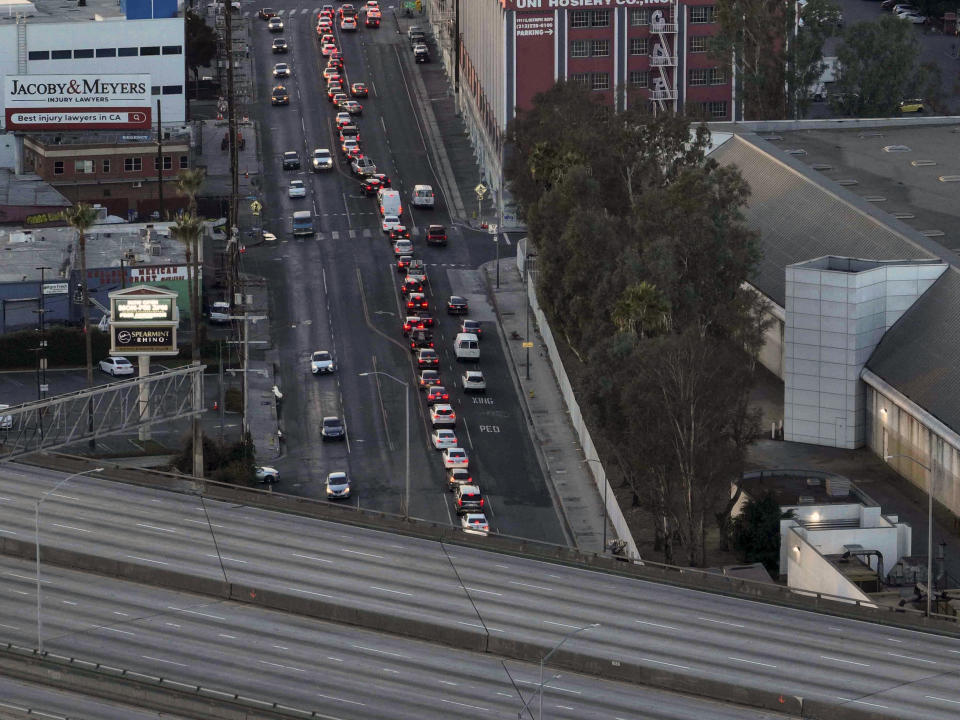 Motorists wait for a signal to change near a section of Interstate 10 that has been closed due to a fire in Los Angeles, Tuesday, Nov. 14, 2023. It will take at least three weeks to repair the freeway damaged in an arson fire, the California governor said Tuesday, leaving the city already accustomed to soul-crushing traffic without part of a vital artery that serves hundreds of thousands of people daily. (AP Photo/Jae C. Hong)