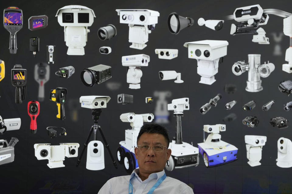 A vendor sits near a board depicting surveillance cameras during Security China 2023 in Beijing, on June 9, 2023. After years of breakneck growth, China's security and surveillance industry is now focused on shoring up its vulnerabilities to the United States and other outside actors, worried about risks posed by hackers, advances in artificial intelligence and pressure from rival governments. The renewed emphasis on self-reliance, combating fraud and hardening systems against hacking was on display at the recent Security China exhibition in Beijing. (AP Photo/Ng Han Guan)