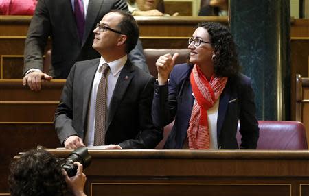 Representatives of Catalan Parliament Jordi Turull (L), Convergencia i Unio (CiU) and Marta Rovira, Catalunya's Republican Left (ERC) react from their seats before delivering their speeches at Spanish Parliament in Madrid April 8, 2014. REUTERS/Sergio Perez