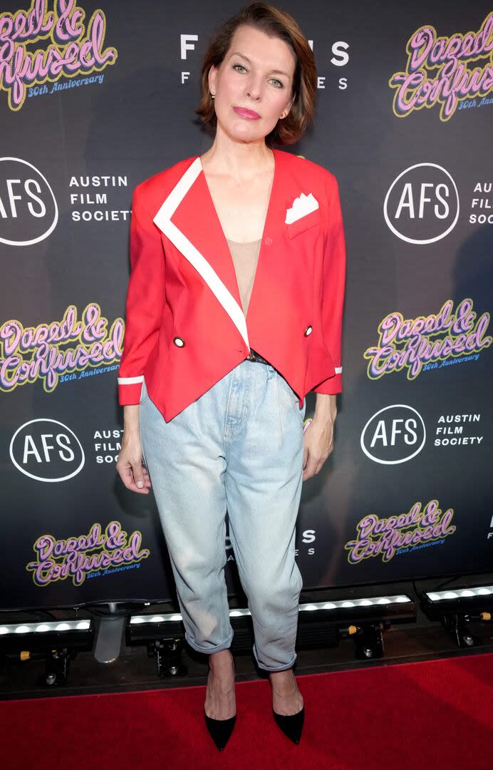 Milla Jovovich se animó al jean para la proyección especial a 30 años del estreno de Rebeldes y confundidos, que tuvo lugar en Texas. La actriz y modelo optó por un diseño baggy que combinó con un saco rojo y stilettos