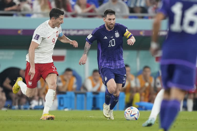 Lionel Messi y Robert Lewandowski disputan la pelota