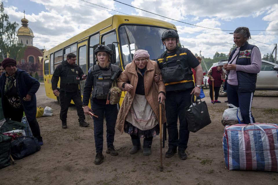 Rescue workers help Liudmila Kalashnik, 88, after evacuation from Vovchansk, Ukraine, Sunday, May 12, 2024. Her husband was killed in their house after a Russian airstrike on the city. (AP Photo/Evgeniy Maloletka)