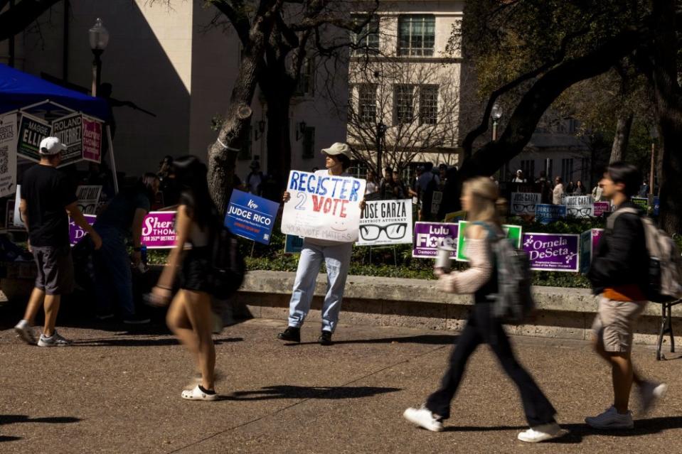 An organizer encourages people to vote outside a polling place at the University of Texas at Austin, on March 5, 2024.<span class="copyright">Ilana Panich-Linsman—The New York Times/Redux</span>