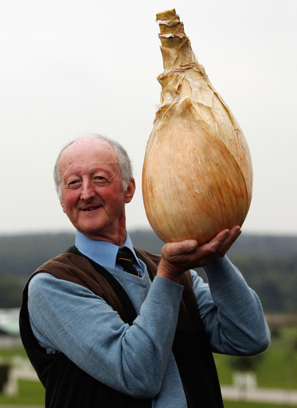 HARROGATE, ENGLAND - SEPTEMBER 16: Gardener Peter Glazebrook poses for photographers with his world record breaking onion at The Harrogate Autumn Flower Show on September 16, 2011 in Harrogate, England. Peter Glazebrook from Newark, Nottinghamshire claimed a Guinness World Record with his giant onion weighing 8.150kg. (Photo by Christopher Furlong/Getty Images)