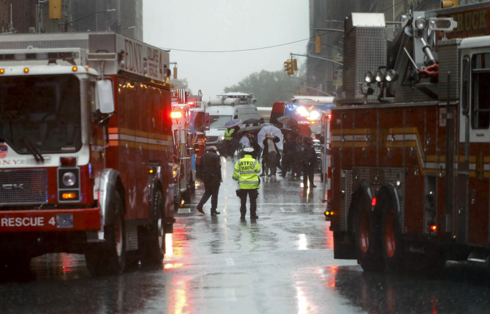 First responders arrive near the scene where a helicopter crash-landed on the roof of a midtown Manhattan skyscraper, Monday, June 10, 2019, in New York. (AP Photo/Mark Lennihan)