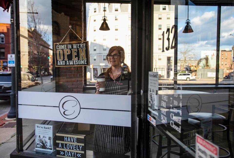 Sandra Martin stands in the window of her business, Elvera’s Cafe in downtown Brockton, which reopened on Monday, Nov. 16, 2020, after being closed for eight months as a result of the coronavirus pandemic.