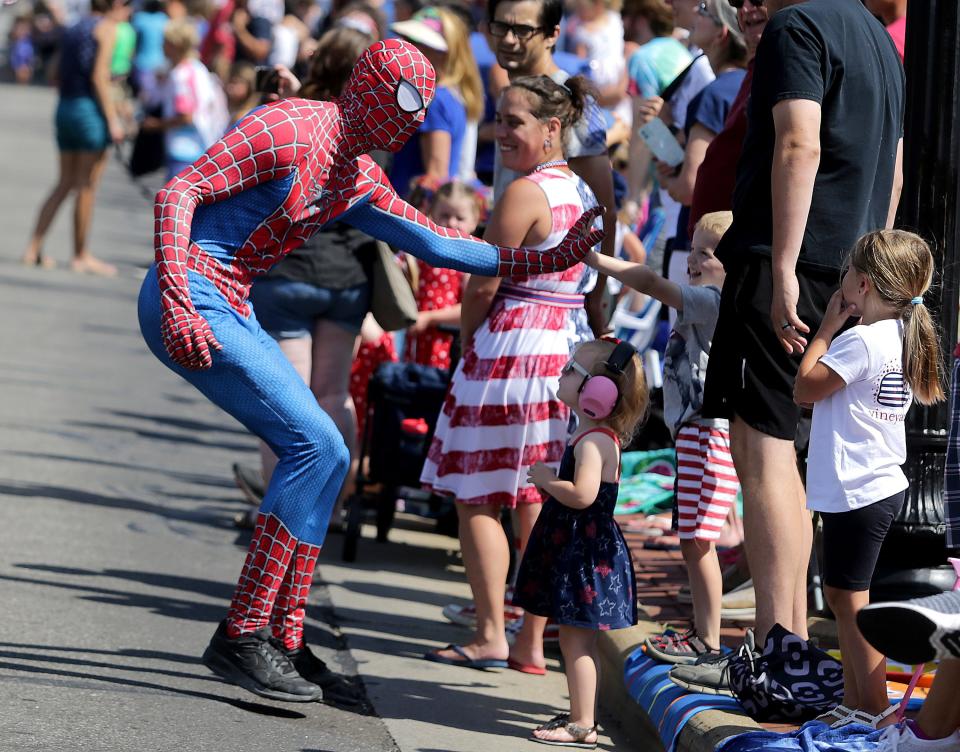 Spider-Man slaps hands with children Monday during the North Canton Fourth of July parade.