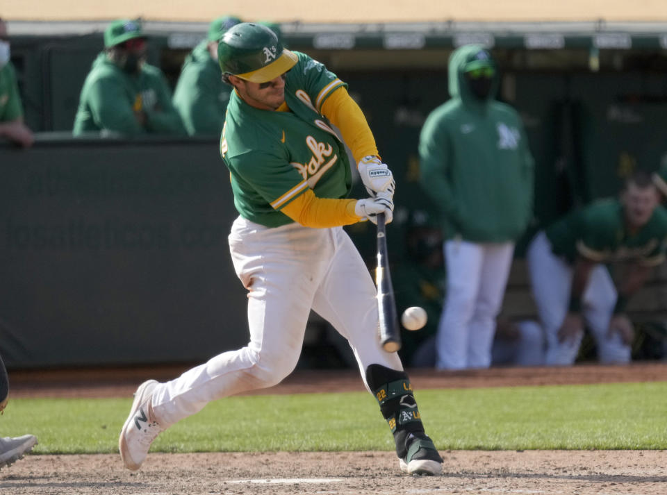 Oakland Athletics' Ramon Laureano (22) hits the ball during the 10th inning of the team's baseball game against the Minnesota Twins on Wednesday, April 21, 2021, in Oakland, Calif. Laureano was safe on a throwing error, and two runs scored. (AP Photo/Tony Avelar)