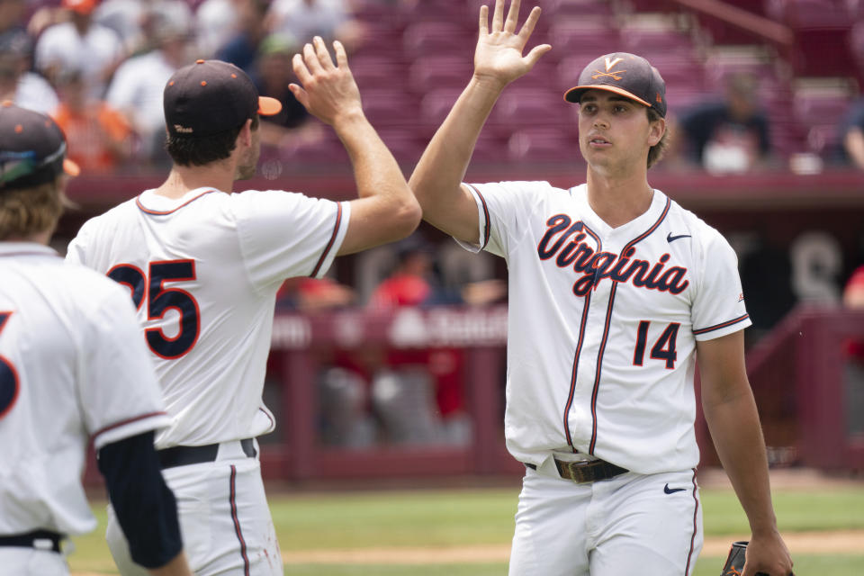 Virginia pitcher Brandon Neeck (14) high fives Griff McGarry (25) at the end of the eighth inning during an NCAA college baseball tournament super regional game against Dallas Baptist, Sunday, June 13, 2021, in Columbia, S.C. (AP Photo/Sean Rayford)