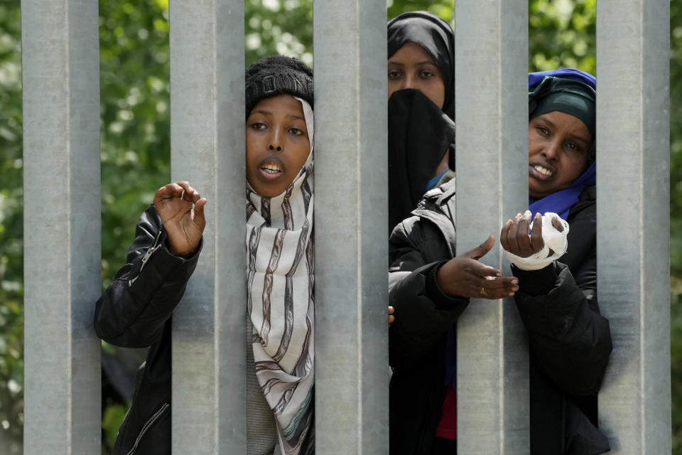 A view of migrants behind the metal barrier border that Poland has erected along the border with Belarus, in Bialowieza Forest, on Wednesday, May 29, 2024. Poland says neighboring Belarus and its main supporter Russia are behind a surging push by migrants in Belarus toward the European Union. (AP Photo/Czarek Sokolowski)