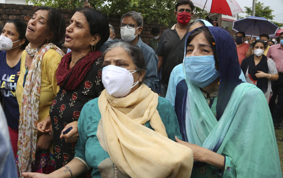 The wife of Rakesh Pandita, who was killed late Wednesday, mourns at their residence, in Jammu, India, Thursday, June. 3, 2021. Assailants fatally shot the politician belonging to India’s ruling party in disputed Kashmir, police said Thursday, blaming separatist rebels for the attack. The unidentified assailants fired at Pandita late Wednesday in the southern town of Tral, where he was visiting a friend, police said. He was declared dead in a hospital. (AP Photo/Channi Anand)