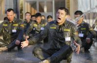 A trainee reacts as he is drenched with water during Tianjiao Special Guard/Security Consultant training on the outskirts of Beijing December 1, 2013. Former Chinese soldier Chen Yongqing has big ambitions for his bodyguard training school Tianjiao, which he says is China's first professional academy to train former soldiers and others as personal security guards. Chen charges 500,000 yuan ($82,400) a year for each protector as China's rich and famous look to bolster their safety and sense of importance. Picture taken December 1, 2013. REUTERS/Jason Lee (CHINA - Tags: BUSINESS SOCIETY) ATTENTION EDITORS: PICTURE 11 OF 26 FOR PACKAGE 'CHINA'S BODYGUARD SCHOOL' TO FIND ALL IMAGES SEARCH 'TIANJIAO'