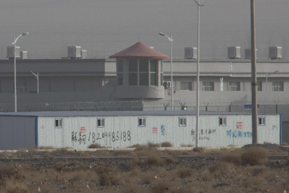 In this Monday, Dec. 3, 2018, photo, a guard tower and barbed wire fences are seen around a facility in the Kunshan Industrial Park in Artux in western China's Xinjiang region. People in touch with state employees in China say the government in the far west region of Xinjiang is destroying documents and taking other steps to tighten control on information. (AP Photo/Ng Han Guan, File)