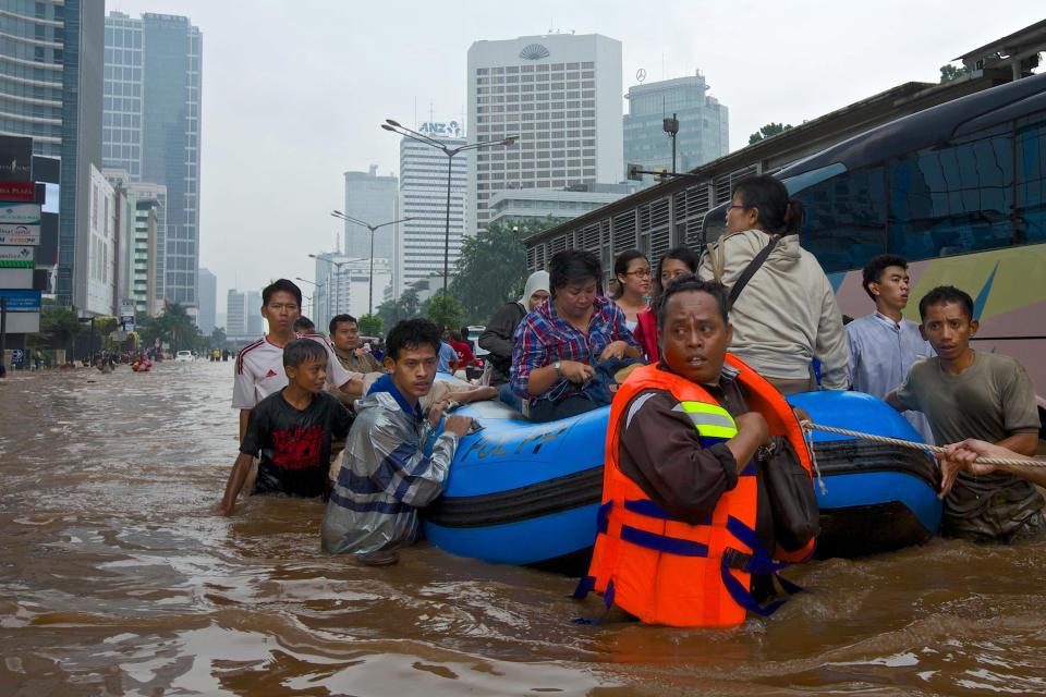 People are stranded by floodwaters in Jakarta's central business district on January 17, 2013 in Jakarta, Indonesia. Thousands of Indonesians were displaced and the capital was covered in many key areas in over a meter of water after days of heavy rain. (Photo by Ed Wray/Getty Images)