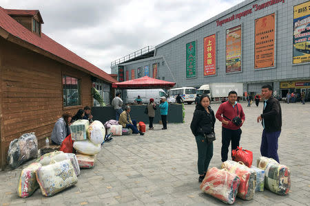 People stand with goods on the Chinese side of the China-Kazakhstan Horgos International Border Cooperation Center (ICBC), in Horgos, China May 19, 2017. Picture taken May 19, 2017. REUTERS/Sue-Lin Wong