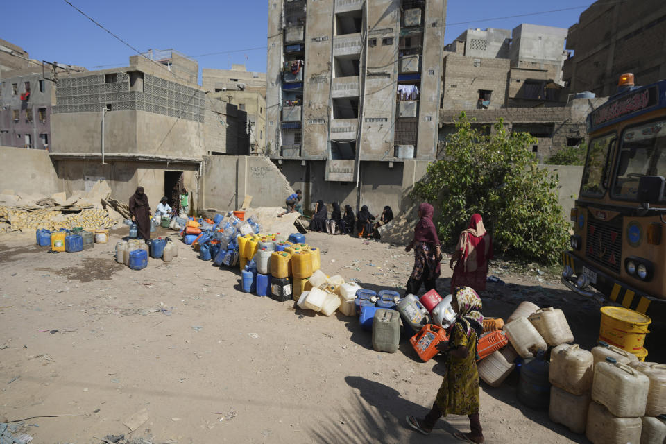 People wait to get drinking water from a water collecting point at a slum area, in Karachi, Pakistan, Tuesday, March 21, 2023. World Water Day will be observed on March 22, to aim to highlight the importance of freshwater and advocate for sustainable management of this vital resource. (AP Photo/Fareed Khan)