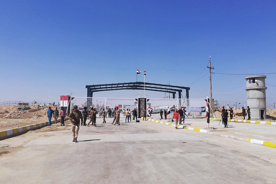 Iraqi and Syrian border guards prepare to open the crossing between the Iraqi town of Qaim and Syria's Boukamal in Anbar province, Iraq, Monday, Sept. 30, 2019. Iraq and Syria have opened a key border crossing between the two neighboring countries seven years after it was closed during Syria's civil war. (AP Photo/Hadi Mizban)