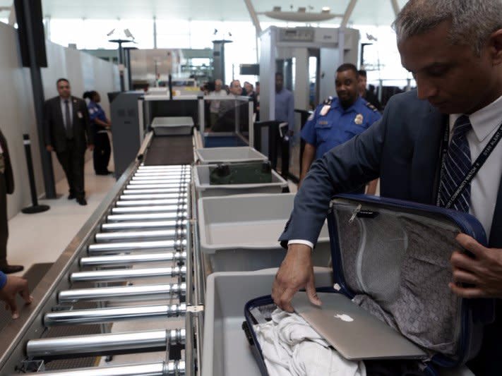 A TSA official removes a laptop from a bag for scanning using the Transport Security Administration's new Automated Screening Lane technology at Terminal 4 of JFK airport in New York City, U.S., May 17, 2017. REUTERS/Joe Penney