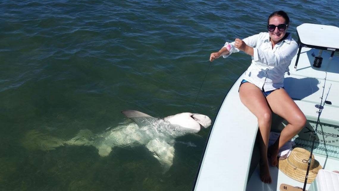 Hailey Porter attempts to calmly pose with a big lemon shark she battled for close to an hour. The shark was released un harmed.