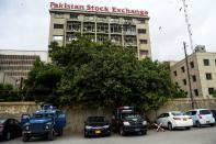 Police vehicles are park in front of the Pakistan Stock Exchange building following an attack by gunmen in Karachi on June 29, 2020. - At least six people were killed when gunmen attacked the Pakistan Stock Exchange in Karachi on June 29, with a policeman among the dead after the assailants opened fire and hurled a grenade at the trading floor, police said. (Photo by Rizwan TABASSUM / AFP) (Photo by RIZWAN TABASSUM/AFP via Getty Images)