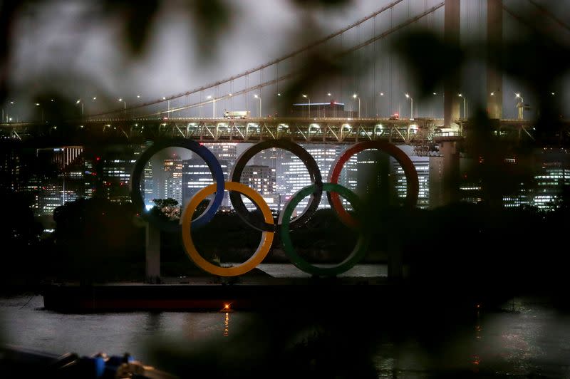 The giant Olympic rings are seen through a tree in Tokyo