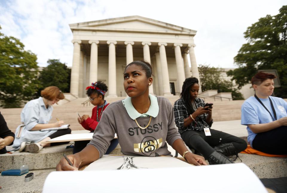 Tyree Brown (C) along with fellow classmates from the Corcoran College of Art and Design takes part in a makeshift class on the steps of the National Gallery of Art, which they did not realize is closed, in Washington October 1, 2013. The students were supposed to hold a class inside the museum today, but did not get word that the U.S. government began a partial shutdown, closing all national museums. The U.S. government partially shut down for the first time in 17 years on Tuesday as a standoff between President Barack Obama and congressional Republicans over healthcare reforms closed many government offices, museums and national parks and slowed everything from trade negotiations to medical research. REUTERS/Kevin Lamarque (UNITED STATES - Tags: POLITICS BUSINESS)