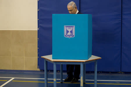 Israel’s Prime Minister Benjamin Netanyahu chooses his ballot as he votes during Israel's parliamentary election in Jerusalem April 9, 2019. Ariel Schalit/Pool via REUTERS