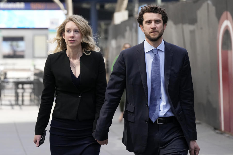 Former Theranos CEO Elizabeth Holmes, left, and her partner, Billy Evans, leave federal court in San Jose, Friday, March 17, 2023. (AP Photo/Jeff Chiu)