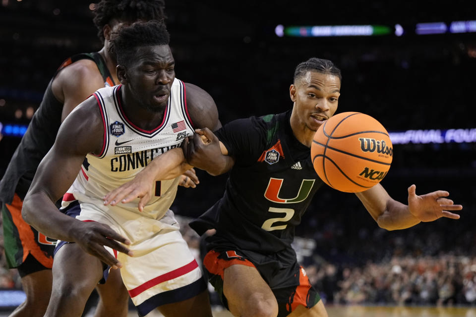 Connecticut forward Adama Sanogo, left, vies for the ball with Miami guard Isaiah Wong during the second half of a Final Four college basketball game in the NCAA Tournament on Saturday, April 1, 2023, in Houston. (AP Photo/Brynn Anderson)