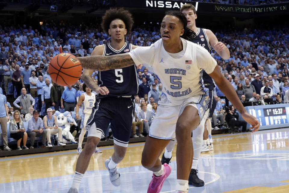 North Carolina forward Armando Bacot, right, tries to control a loose ball in front of Duke guard Tyrese Proctor, left, during the first half of an NCAA college basketball game Saturday, Feb. 3, 2024, in Chapel Hill, N.C. (AP Photo/Chris Seward)