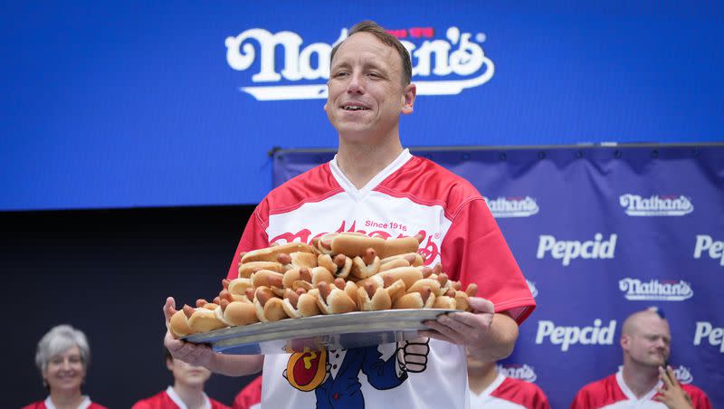 Competitive eater Joey Chestnut holds a plate of hot dogs representing his world record for eating 76 hot dogs and buns in ten minutes during a weigh-in ceremony before the Nathan’s Famous July Fourth hot dog eating contest, Monday, July 3, 2023, in New York.