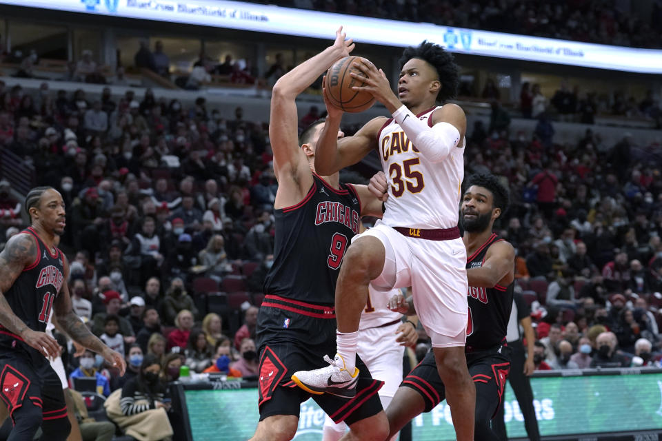 Cleveland Cavaliers' Isaac Okoro (35) drives past Chicago Bulls' Nikola Vucevic during the first half of an NBA basketball game Wednesday, Jan. 19, 2022, in Chicago. (AP Photo/Charles Rex Arbogast)