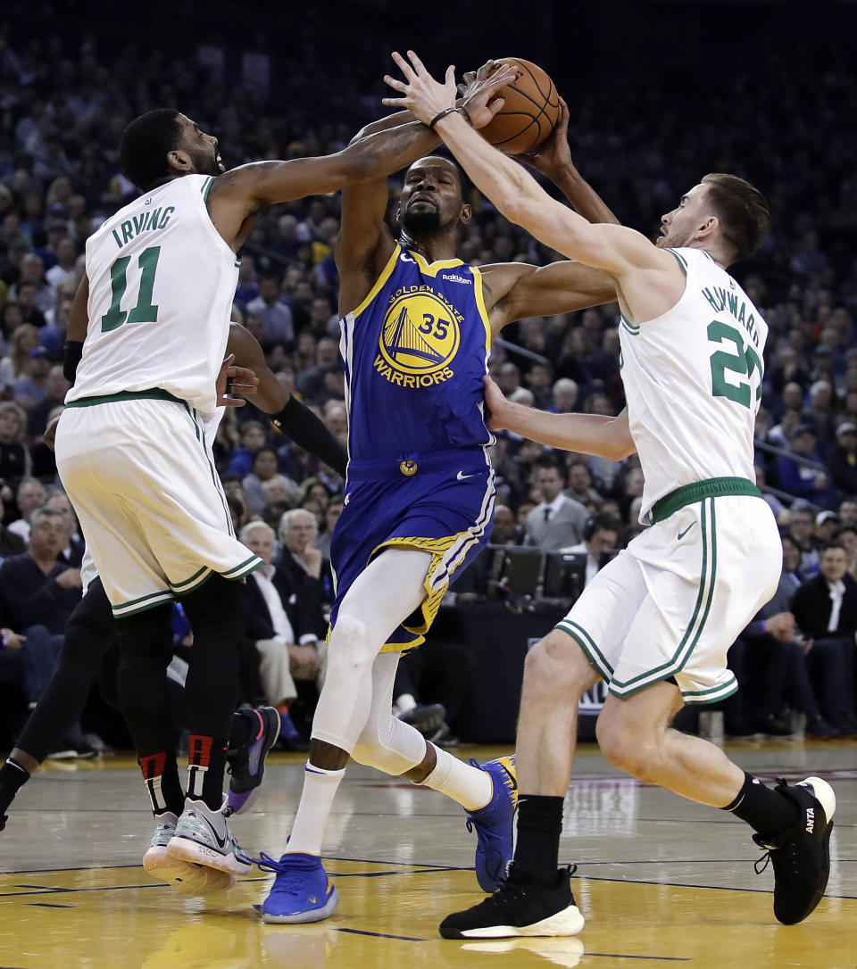 Boston Celtics' Kyrie Irving, left, and Gordon Hayward, right, defend against Golden State Warriors' Kevin Durant (35) during the first half of an NBA basketball game Tuesday, March 5, 2019, in Oakland, Calif. (AP Photo/Ben Margot)