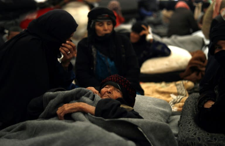 An elderly Syrian woman whose family fled the deadly US-backed offensive by Kurdish-led forces on the Islamic State group enclave around Hajin, lies in a diplaced persons' camp in Kurdish-held territory on December 8, 2018