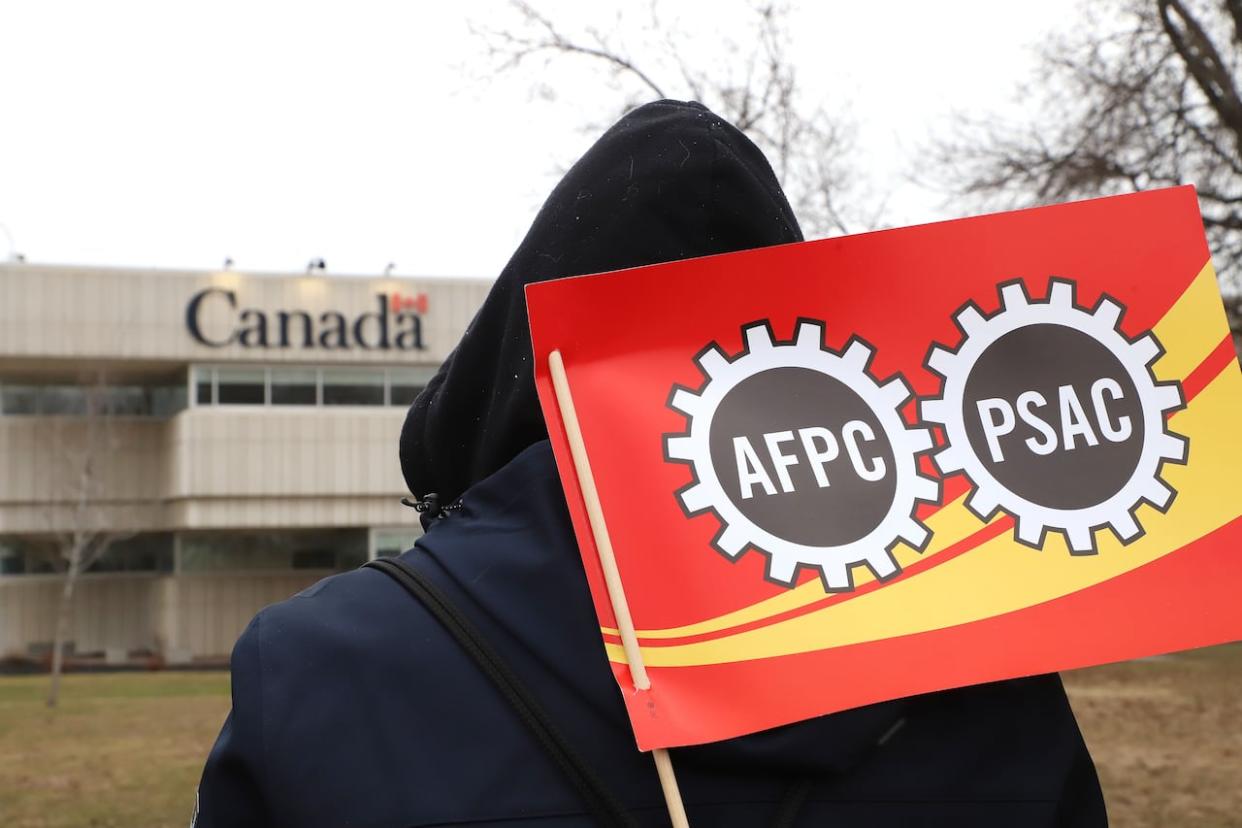Public Service Alliance of Canada workers and supporters picket outside the Canada Revenue Agency office in Sudbury, Ont., in April 2023. PSAC says an agreement to not make group remote work decisions was a major part of the accepted deal to end that strike. (Gino Donato/The Canadian Press - image credit)