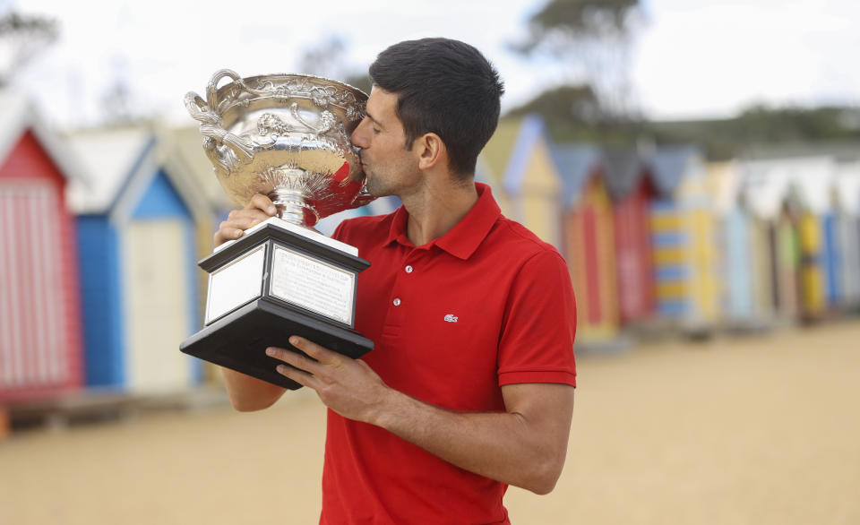 Serbia's Novak Djokovic kisses the Norman Brookes Challenge Cup at Brighton Beach after defeating Russia's Daniil Medvedev on Sunday Feb. 21, 2021 in the men's singles final at the Australian Open tennis championship in Melbourne, Australia, Monday, Feb. 22, 2021.(AP Photo/Hamish Blair)