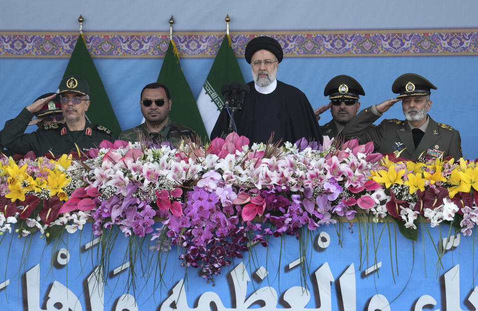 Iranian President Ebrahim Raisi, center, listens to the national anthem as the army commander Gen. Abdolrahim Mousavi, right, and Chief of the General Staff of the Armed Forces Gen. Mohammad Hossein Bagheri, left, salute during the Army Day parade in front of the mausoleum of the late revolutionary founder Ayatollah Khomeini just outside Tehran, Iran, Tuesday, April 18, 2023. President Raisi reiterated threats against Israel while though he stayed away from criticizing Saudi Arabia as Tehran seeks a détente with the kingdom. (AP Photo/Vahid Salemi)