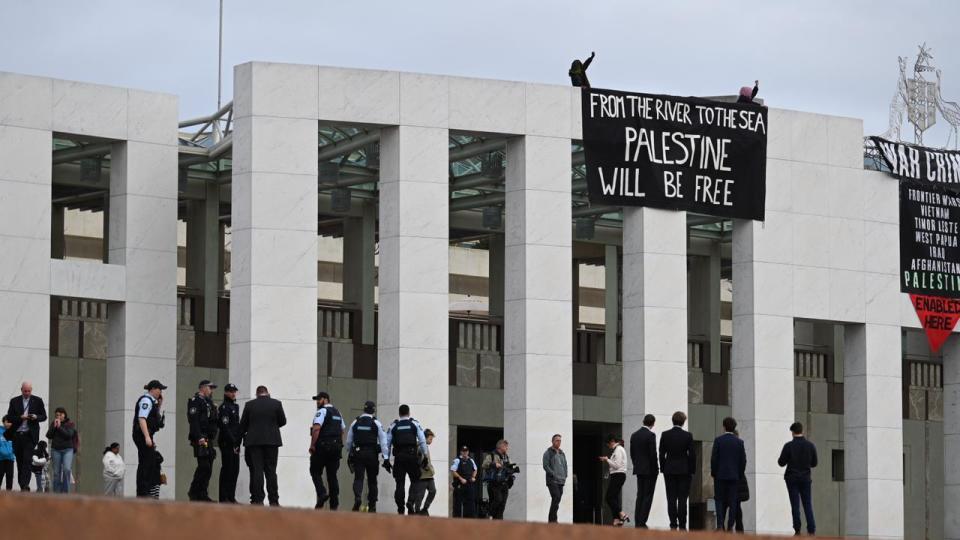 AFP officers are on the scene where protesters have taken to the roof of Parliament House to unfurl a banner. Picture: NewsWire/ Martin Ollman