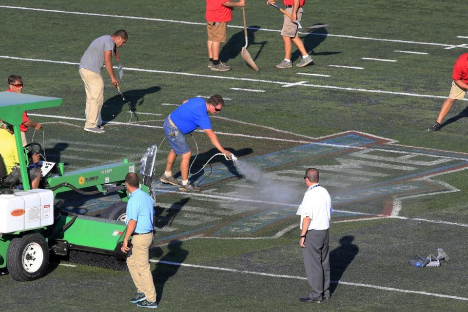 Workers tend to the field at Hall of Fame Stadium (AP)