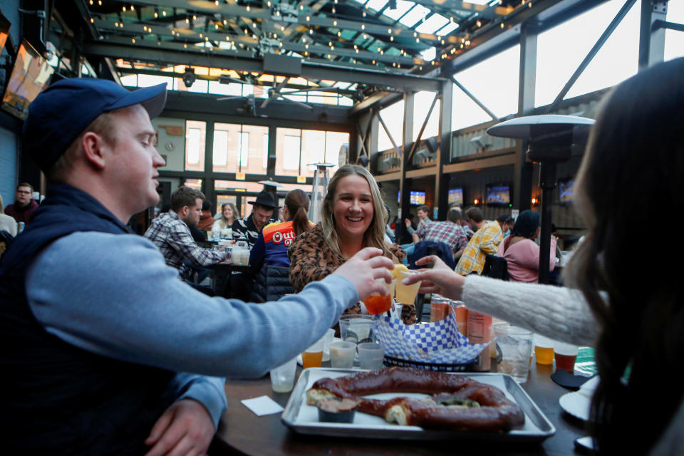 Kevin Kahovec, Mary Kate McGovern, and Mave McGovern drink at Rizzo's Bar &amp; Inn as COVID restrictions are relaxed in Chicago, March 6, 2021. REUTERS/Eileen T. Meslar