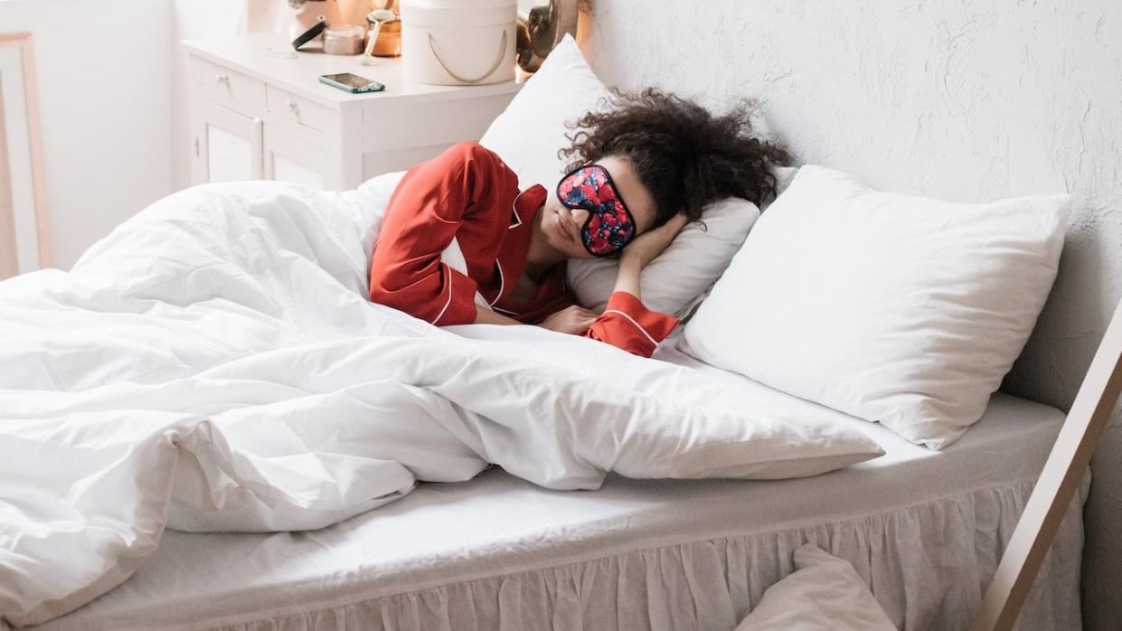  Woman in bed wearing sleep mask 