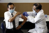 Tokyo Medical Center director Kazuhiro Araki, left, receives a dose of COVID-19 vaccine in Tokyo Wednesday, Feb. 17, 2021. Japan's first coronavirus shots were given to health workers Wednesday, beginning a vaccination campaign considered crucial to holding the already delayed Tokyo Olympics. (Behrouz Mehri/Pool Photo via AP)