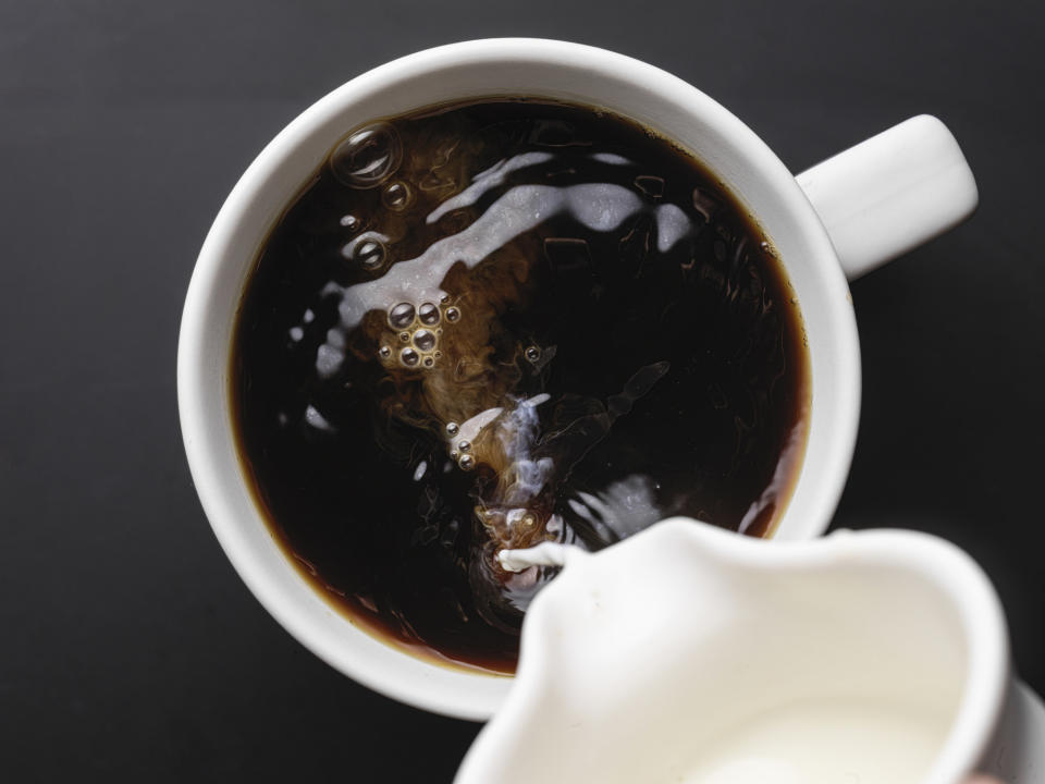 Pouring milk into coffee.