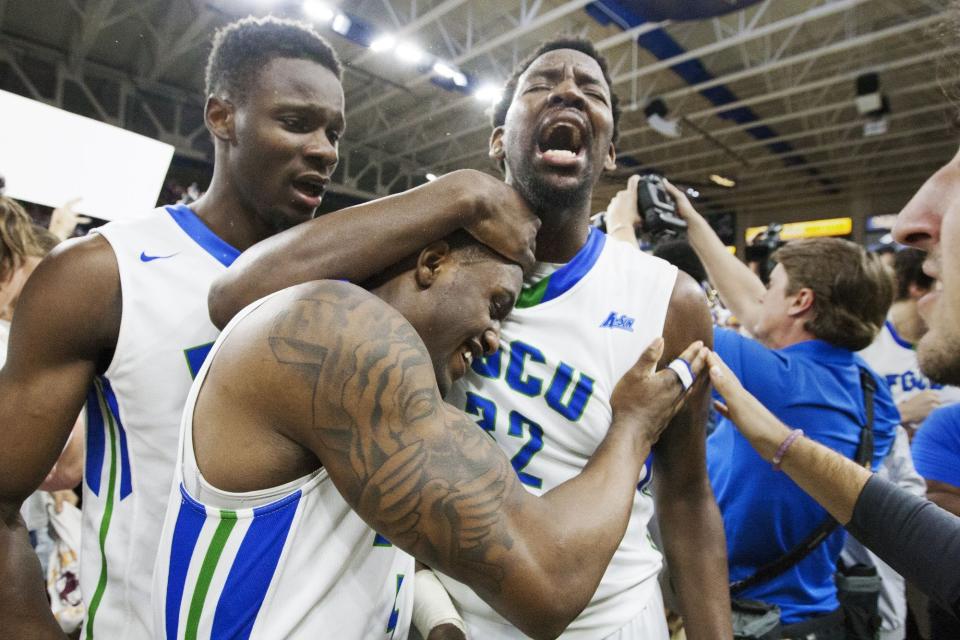 FGCU’s Demetris Morant, left, Antravious Simmons, top, and Zach Johnson celebrate their 80-78 overtime win over Stetson in the ASUN championship on Sunday, March 6, 2016.