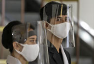 Staff wear face shields as a precaution against the new coronavirus at the reception desk of Senayan City shopping mall in Jakarta, Indonesia, Tuesday, June 9, 2020. As Indonesia's overall virus caseload continues to rise, the capital city has moved to restore normalcy by lifting some restrictions this week, saying that the spread of the virus in the city of 11 million has slowed after peaking in mid-April. (AP Photo/Dita Alangkara)