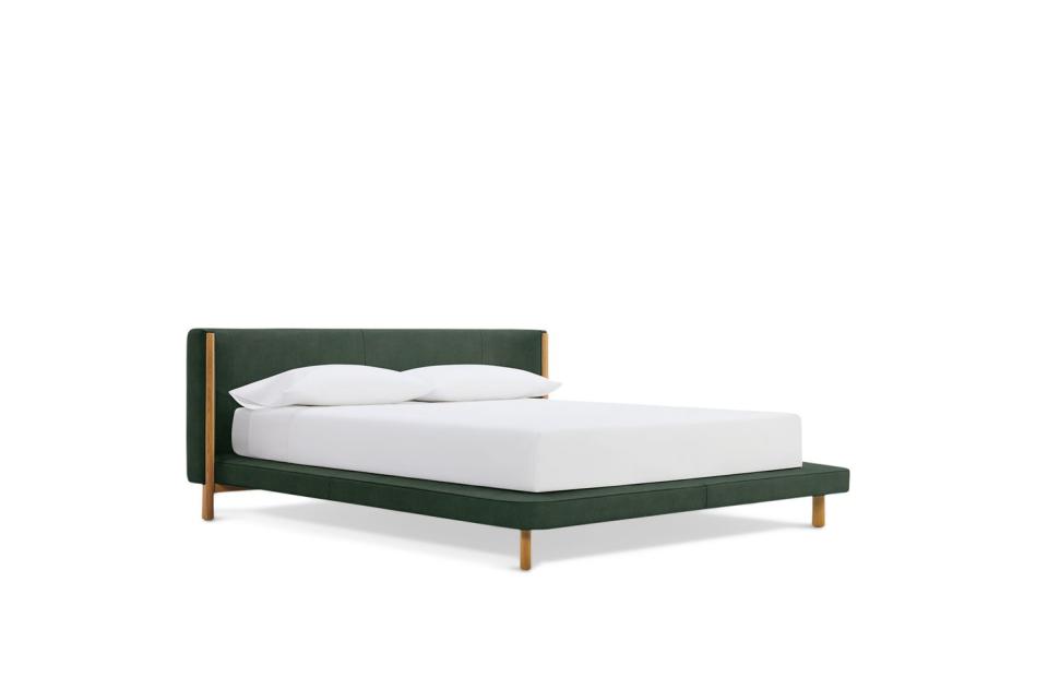 green low platform bed with brown legs and accents
