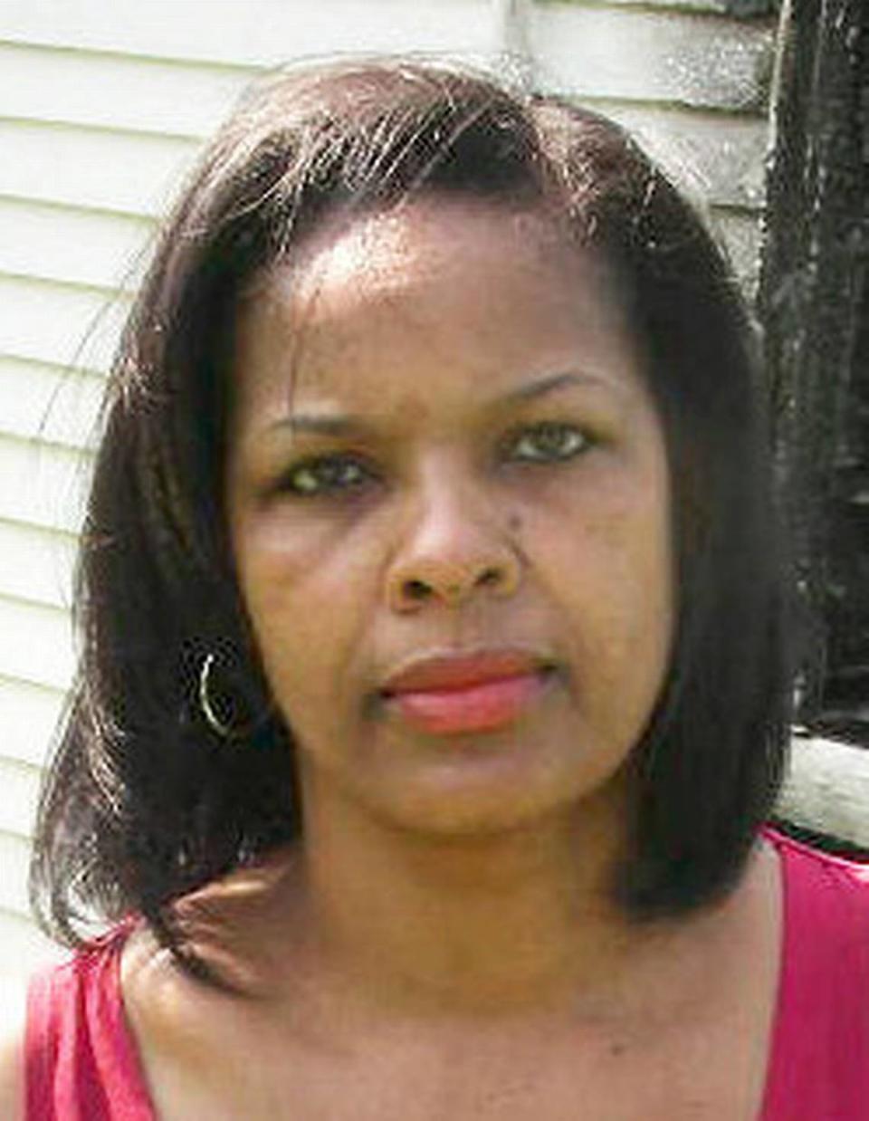 Rich Square native Shelia Moses, photographed in 2012, holds a portrait of her brother, Daniel, outside the burned remains of the family house. She has used the house as a centerpiece to her young adult fiction.