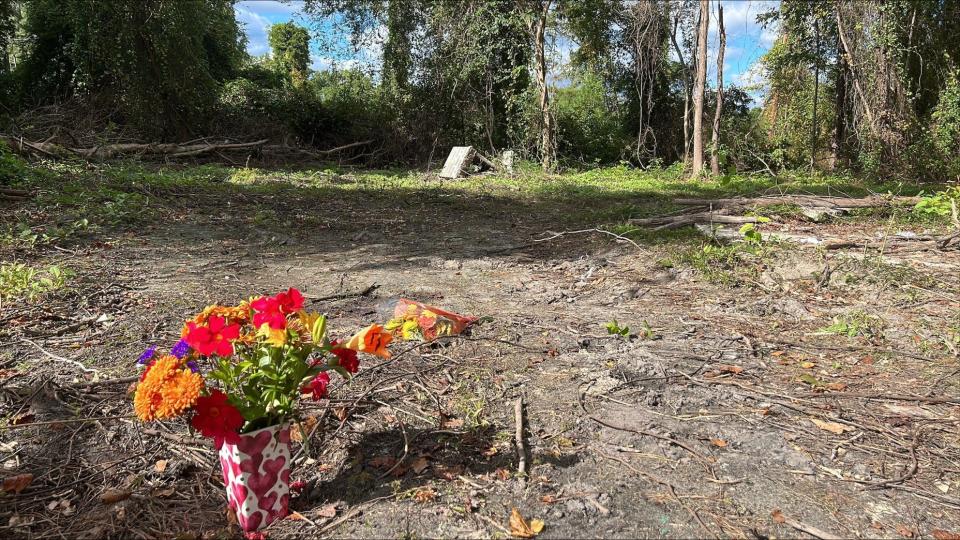 A memorial of flowers marks the ground near the spot where the body of Crystal Loughran, 40, was found Oct. 11, 2023, in woods off Cedric Street in Fayetteville. A man who picked her up from her home a day earlier is accused of killing her.